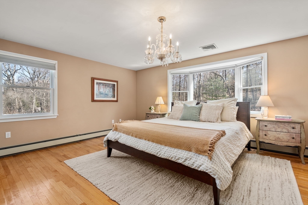 88 Robinwood Avenue Needham, MA 02492 - Photo 16 of 29 a spacious bedroom with a bed and a chandelier