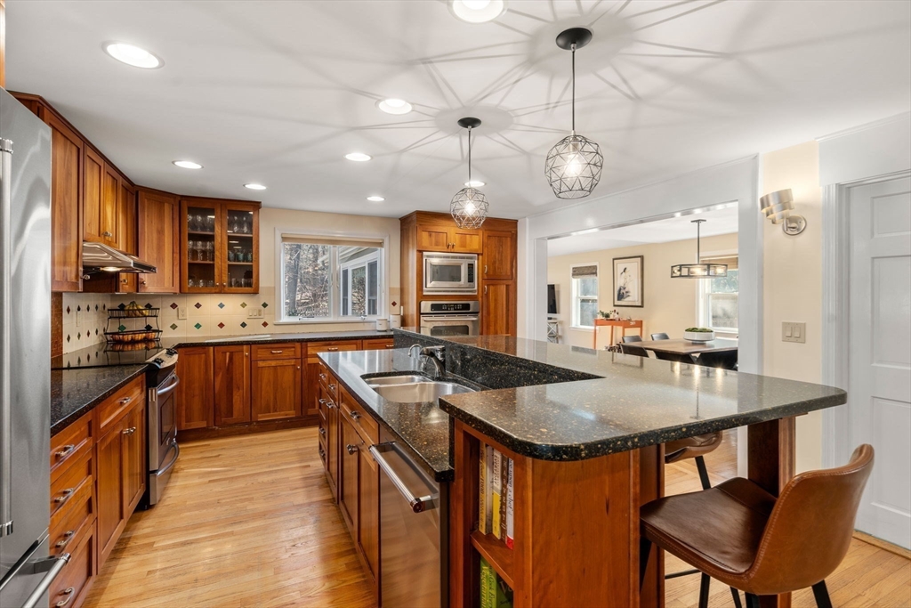 88 Robinwood Avenue Needham, MA 02492 - Photo 8 of 29 a kitchen with stainless steel appliances granite countertop a kitchen island a stove a table and chairs