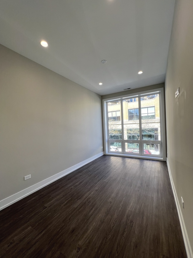 3244 North Lincoln Avenue, Unit 4 Chicago, IL 60657 - Photo 11 of 14 an empty room with wooden floor and windows