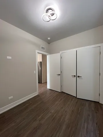 an empty room with wooden floor and window