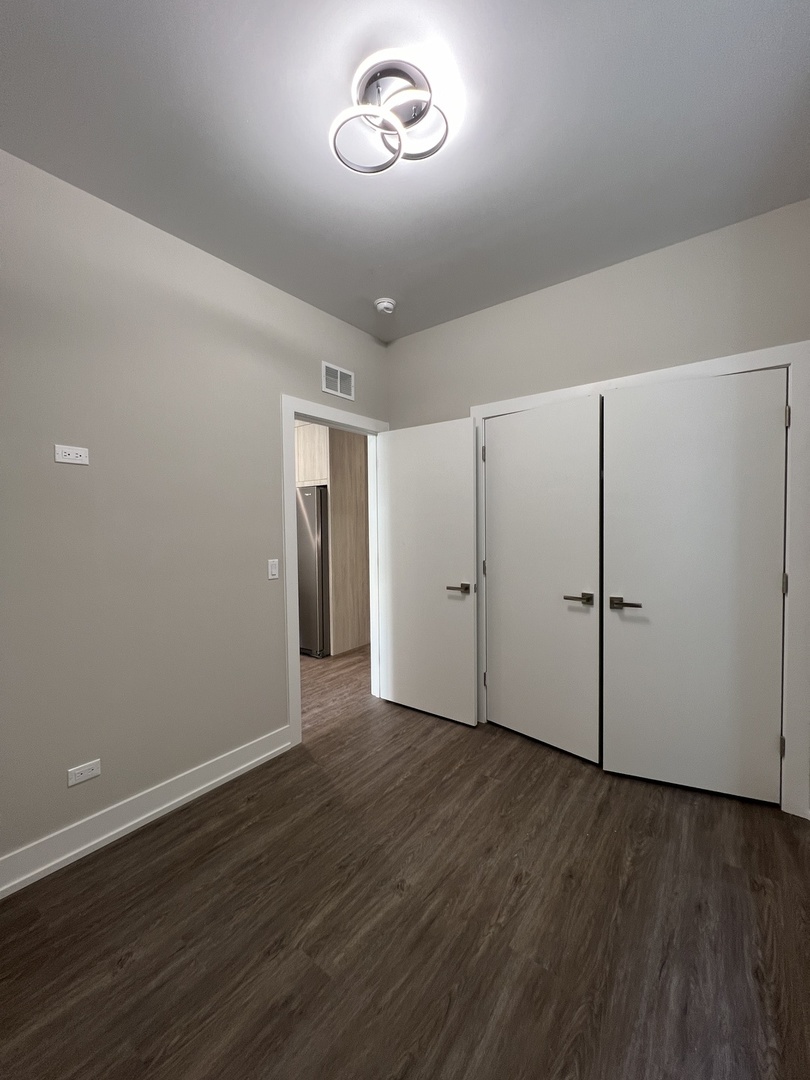 3244 North Lincoln Avenue, Unit 4 Chicago, IL 60657 - Photo 8 of 14 an empty room with wooden floor and window
