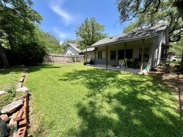 a view of a house with backyard garden and sitting area
