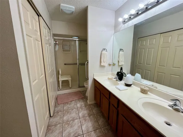 a bathroom with a double vanity sink mirror and shower