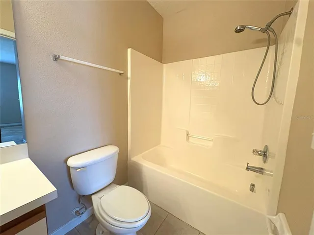 a white toilet sitting next to a bath tub