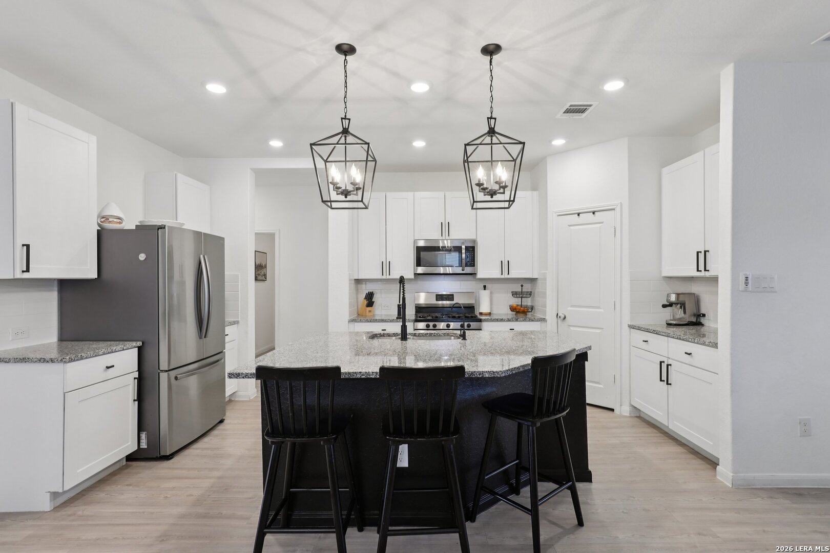9062 Austin Seguin, TX 78155 - Photo 14 of 43 a kitchen with stainless steel appliances kitchen island granite countertop a dining table chairs and white cabinets