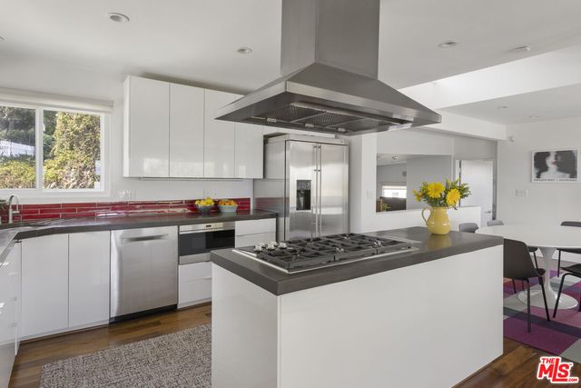 a kitchen with stainless steel appliances granite countertop a sink and a stove