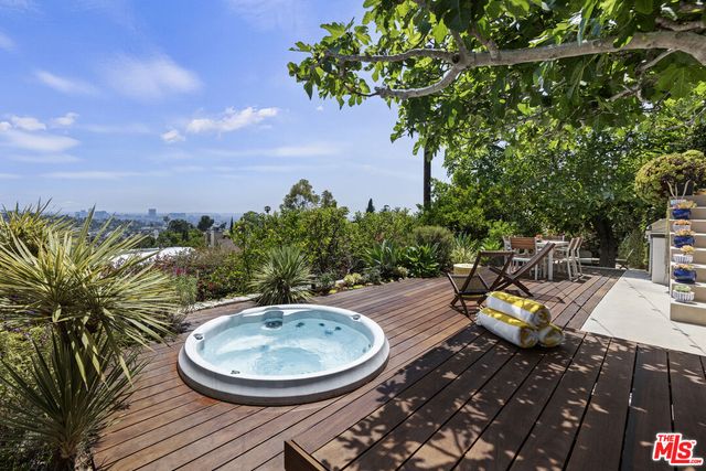 a view of a patio with table and chairs with wooden floor and fence
