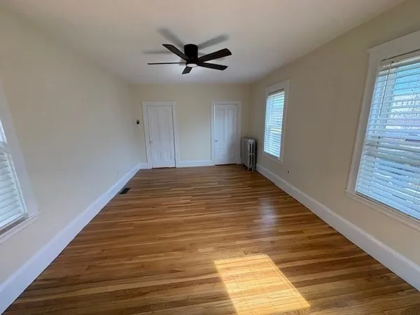 a view of empty room with wooden floor