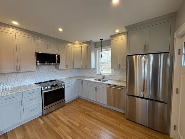 a kitchen with a refrigerator and a stove top oven