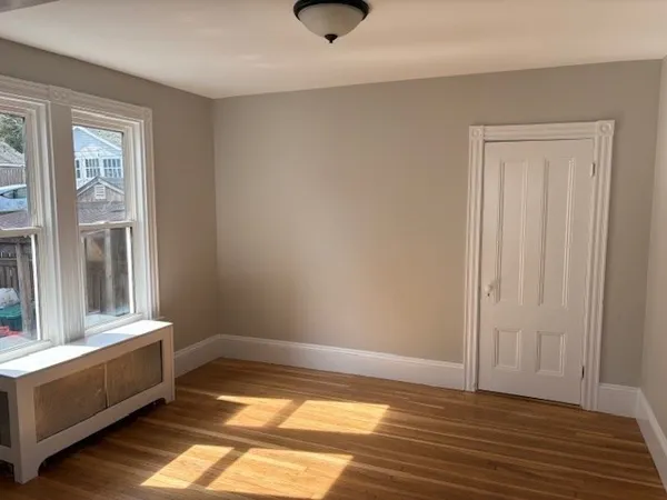 a view of a room with wooden floor and a window