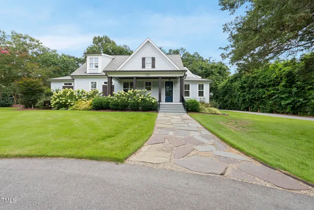 a view of a dining room and livingroom with furniture wooden floor a chandelier