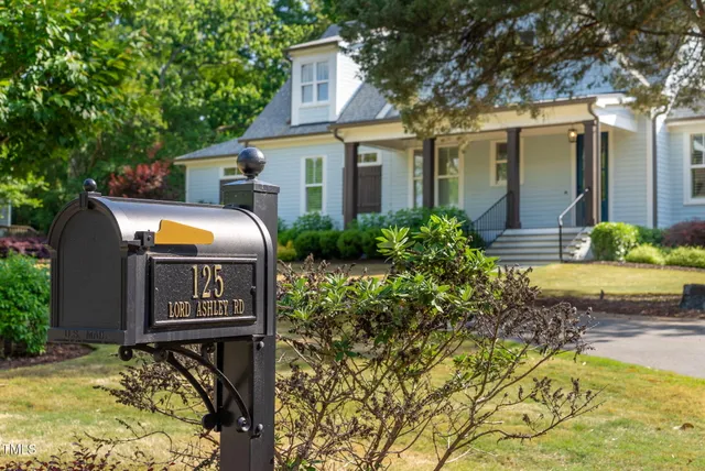 a kitchen with stainless steel appliances kitchen island granite countertop a dining table chairs and white cabinets