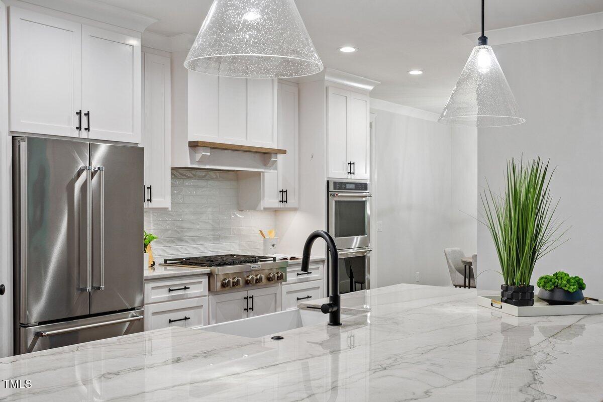 125 Lord Ashley Road Raleigh, NC 27610 - Photo 24 of 85 a kitchen with stainless steel appliances kitchen island granite countertop a refrigerator a stove and a sink
