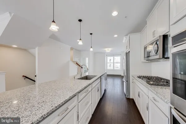 a kitchen with counter top space a sink stainless steel appliances and cabinets