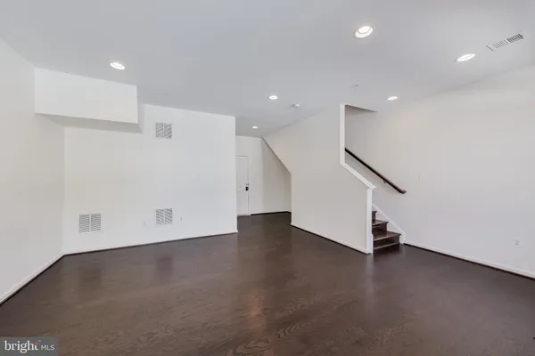 an empty room with wooden floor and window