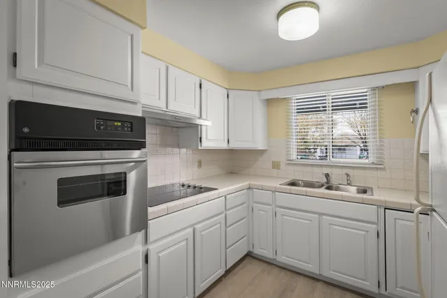 a kitchen with cabinets appliances a sink and a window