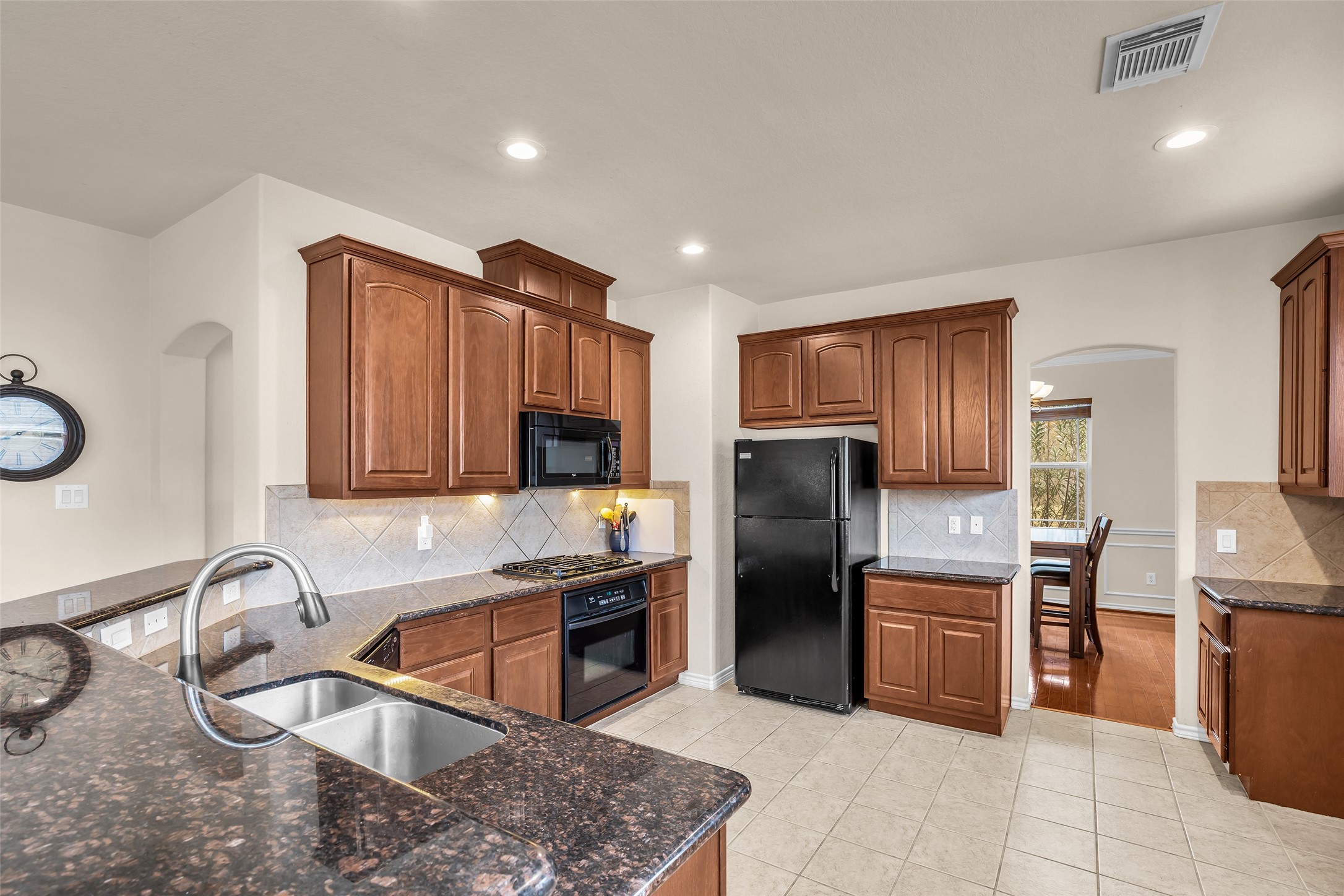 629 Spring Forest Drive Conroe, TX 77302 - Photo 15 of 38 a kitchen with stainless steel appliances granite countertop a sink stove and refrigerator