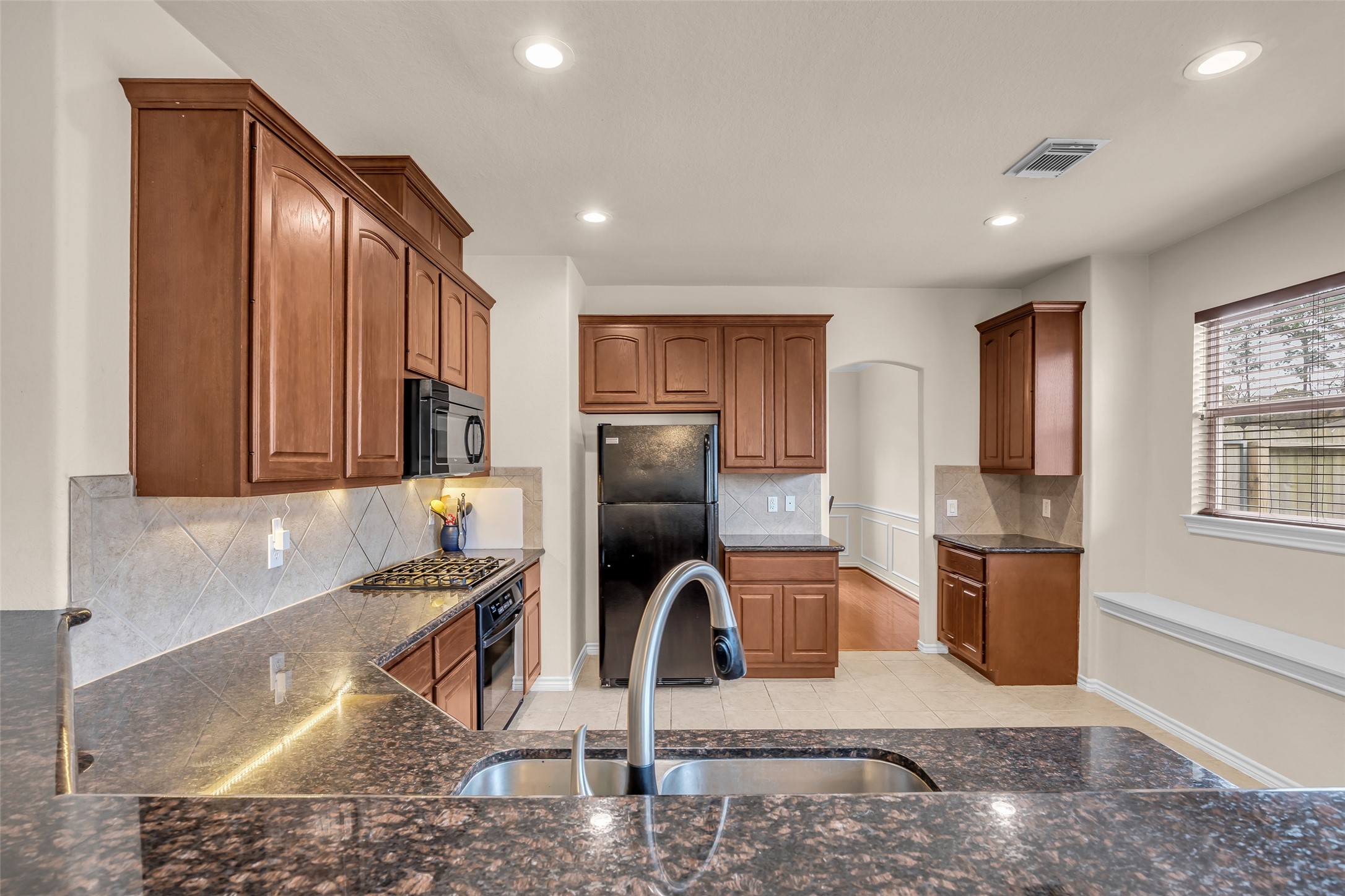 629 Spring Forest Drive Conroe, TX 77302 - Photo 16 of 38 a kitchen with stainless steel appliances granite countertop a sink refrigerator and microwave