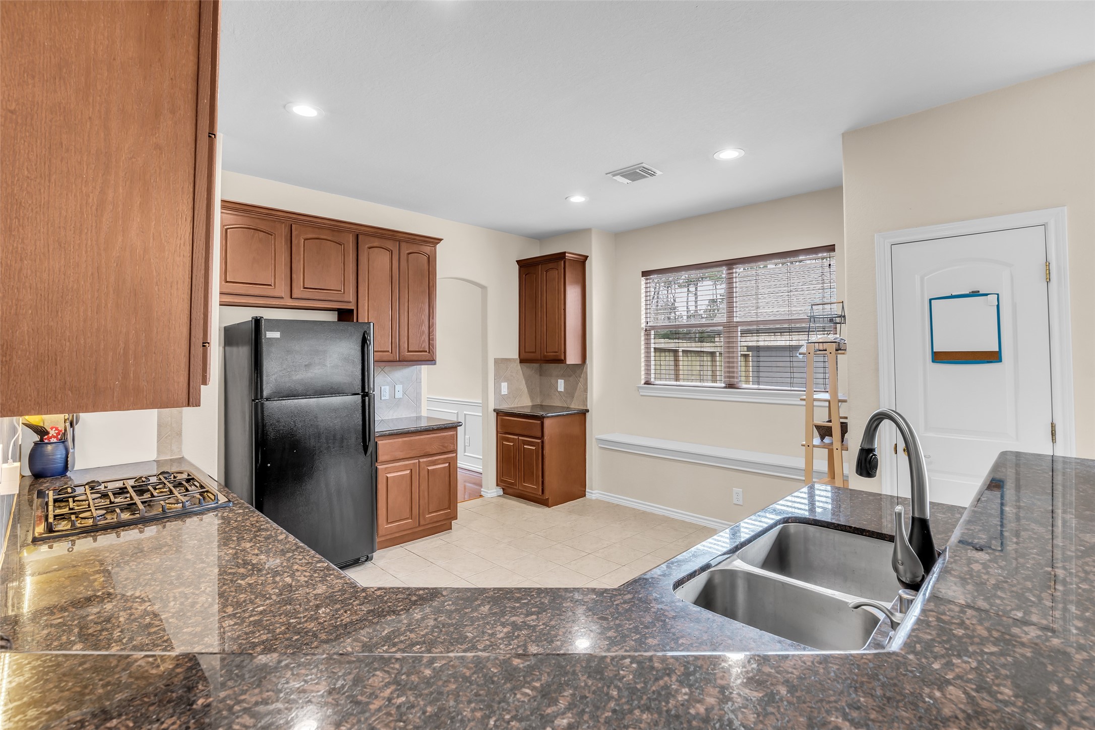 629 Spring Forest Drive Conroe, TX 77302 - Photo 19 of 38 a kitchen with stainless steel appliances granite countertop a sink stove and refrigerator