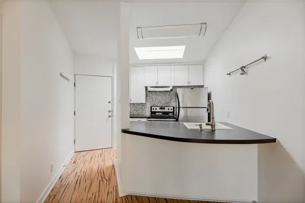 a kitchen with kitchen island a sink and a refrigerator