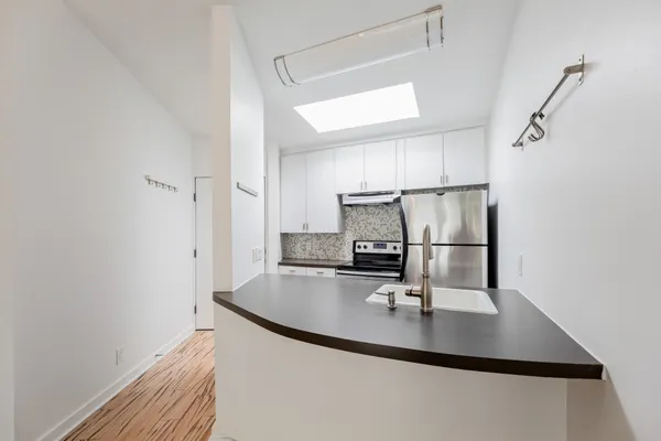 a kitchen with kitchen island a counter top space appliances and cabinets