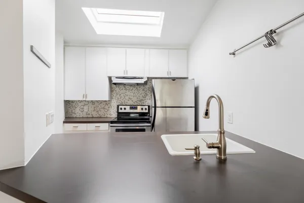 a kitchen with a refrigerator and white cabinets