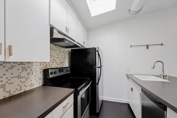 a kitchen with stainless steel appliances granite countertop a sink and a stove