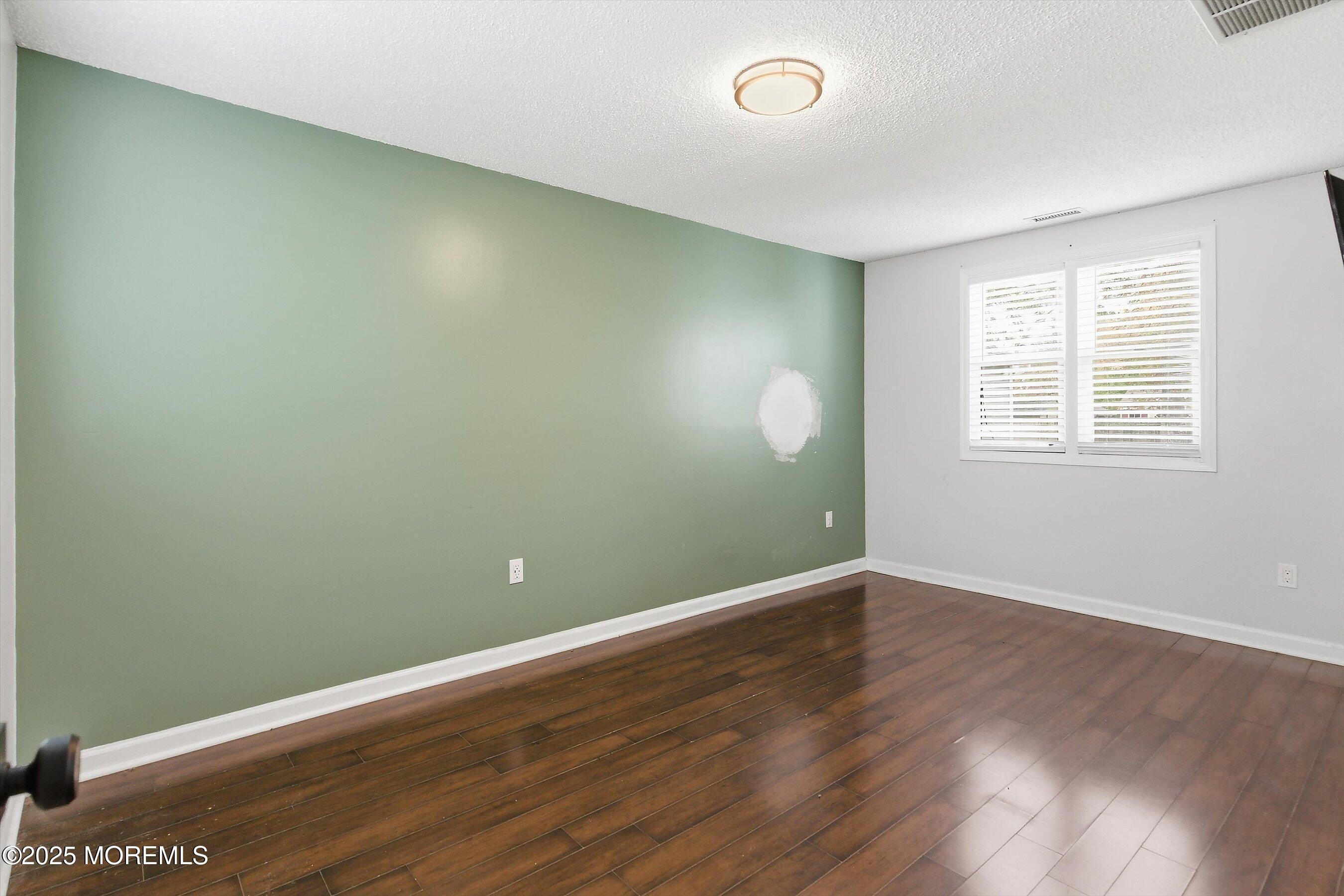 625 Drum Point Road Brick, NJ 08723 - Photo 9 of 22 an empty room with wooden floor and windows
