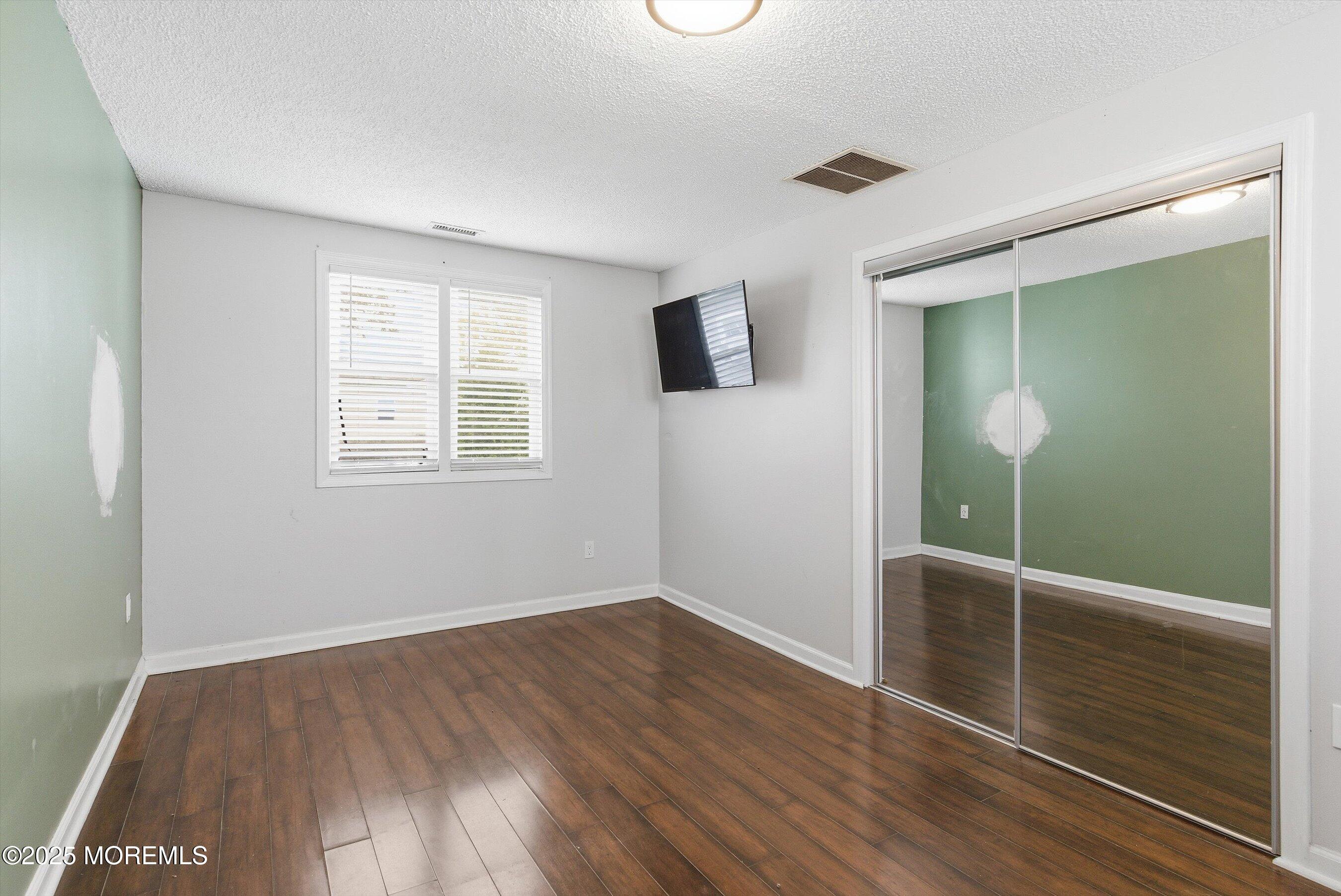 625 Drum Point Road Brick, NJ 08723 - Photo 10 of 22 an empty room with wooden floor and windows