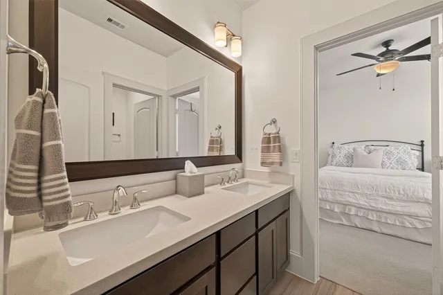 a en suite bathroom with a double vanity sink and a mirror