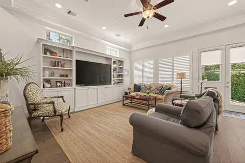 a living room with furniture a flat screen tv and a floor to ceiling window