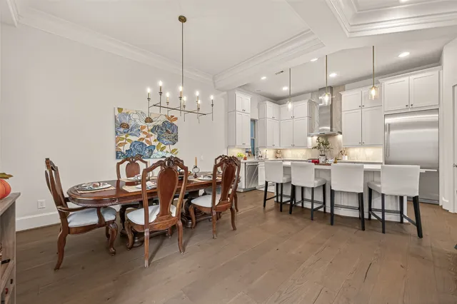 a dining room with furniture a chandelier and kitchen view