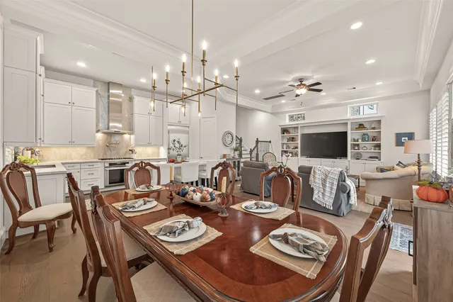 a view of a dining room and livingroom view with furniture wooden floor a chandelier