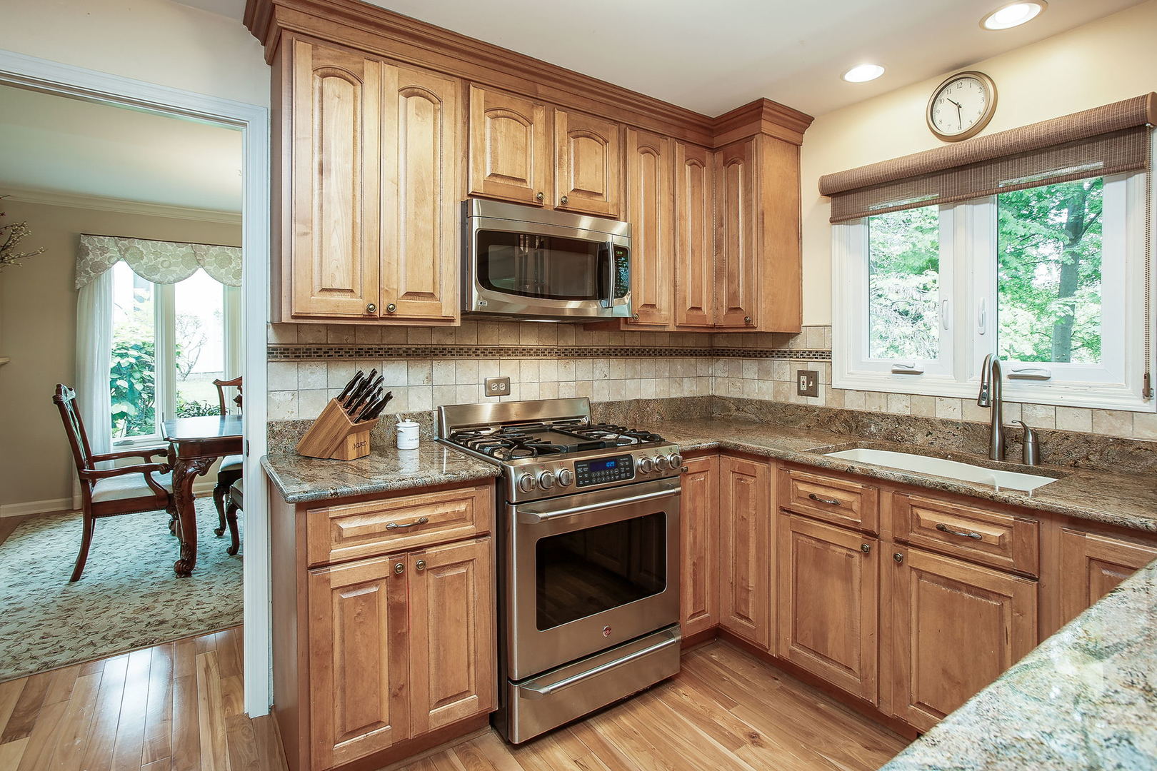 110 Stuarton Drive Wheaton, IL 60189 - Photo 18 of 30 a kitchen with stainless steel appliances granite countertop a stove a sink and a microwave