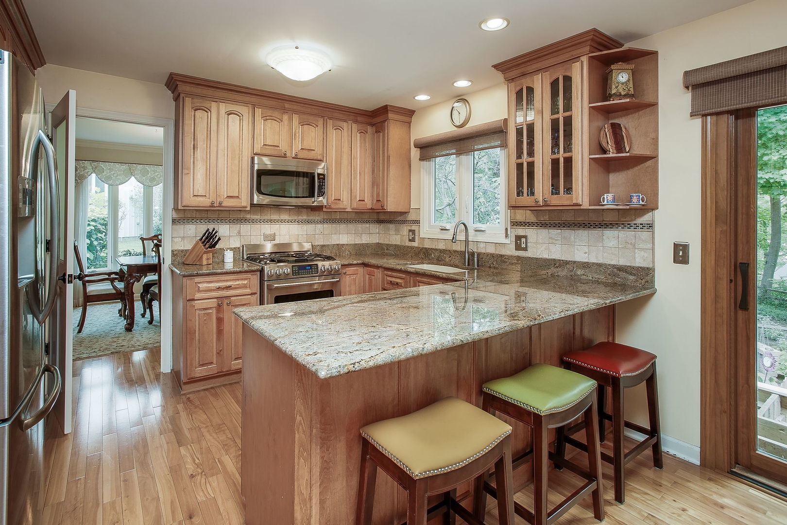 110 Stuarton Drive Wheaton, IL 60189 - Photo 2 of 30 a kitchen with stainless steel appliances granite countertop a table chairs sink and cabinets