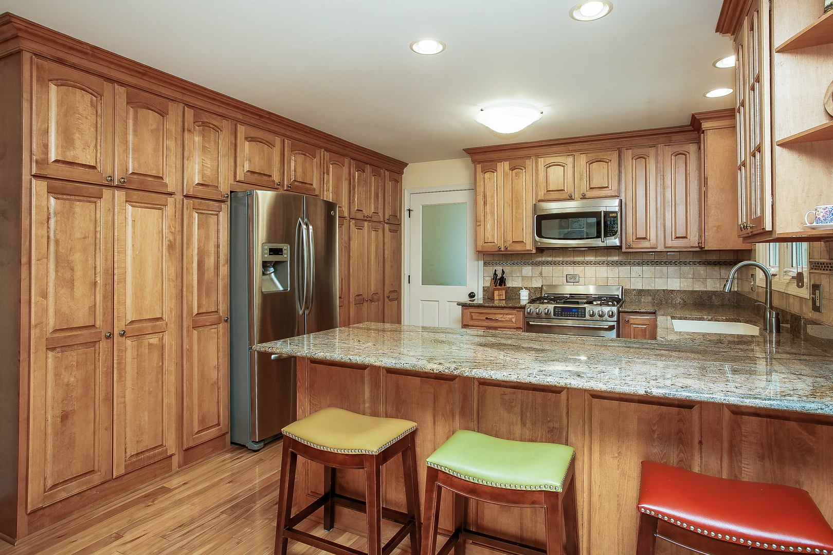 110 Stuarton Drive Wheaton, IL 60189 - Photo 3 of 30 a kitchen with kitchen island granite countertop wooden floor cabinets and appliances