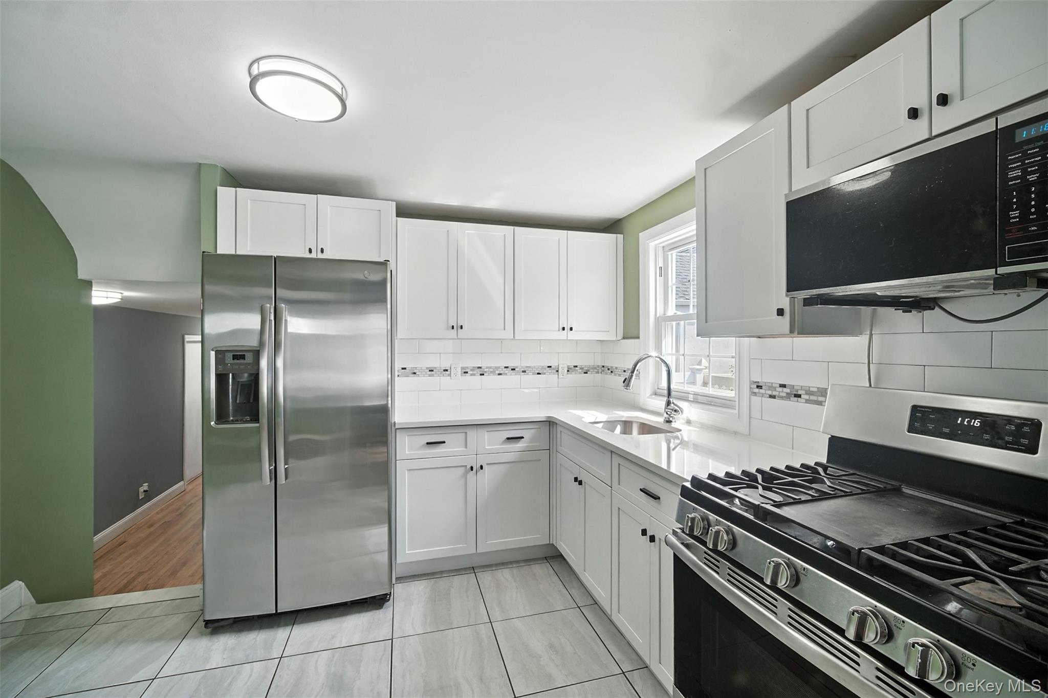 112 Casper Street Valley Stream, NY 11580 - Photo 8 of 26 a kitchen with stainless steel appliances a sink stove and refrigerator