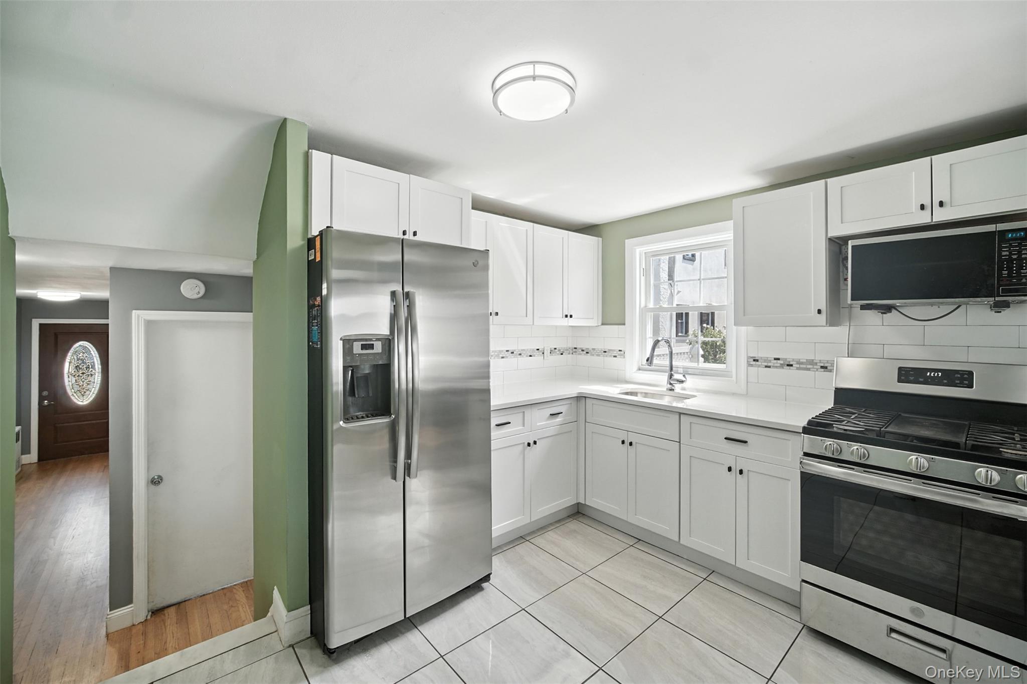 112 Casper Street Valley Stream, NY 11580 - Photo 9 of 26 a kitchen with a refrigerator stove and sink