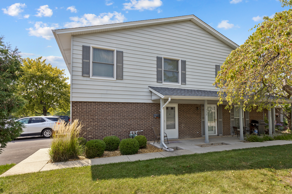 772 Leicester Road, Unit 772 Elk Grove Village, IL 60007 - Photo 1 of 21 a front view of a house with a yard and garage
