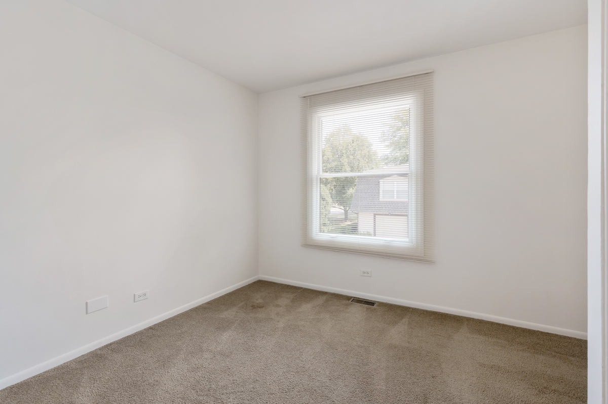 772 Leicester Road, Unit 772 Elk Grove Village, IL 60007 - Photo 12 of 21 an empty room with a window