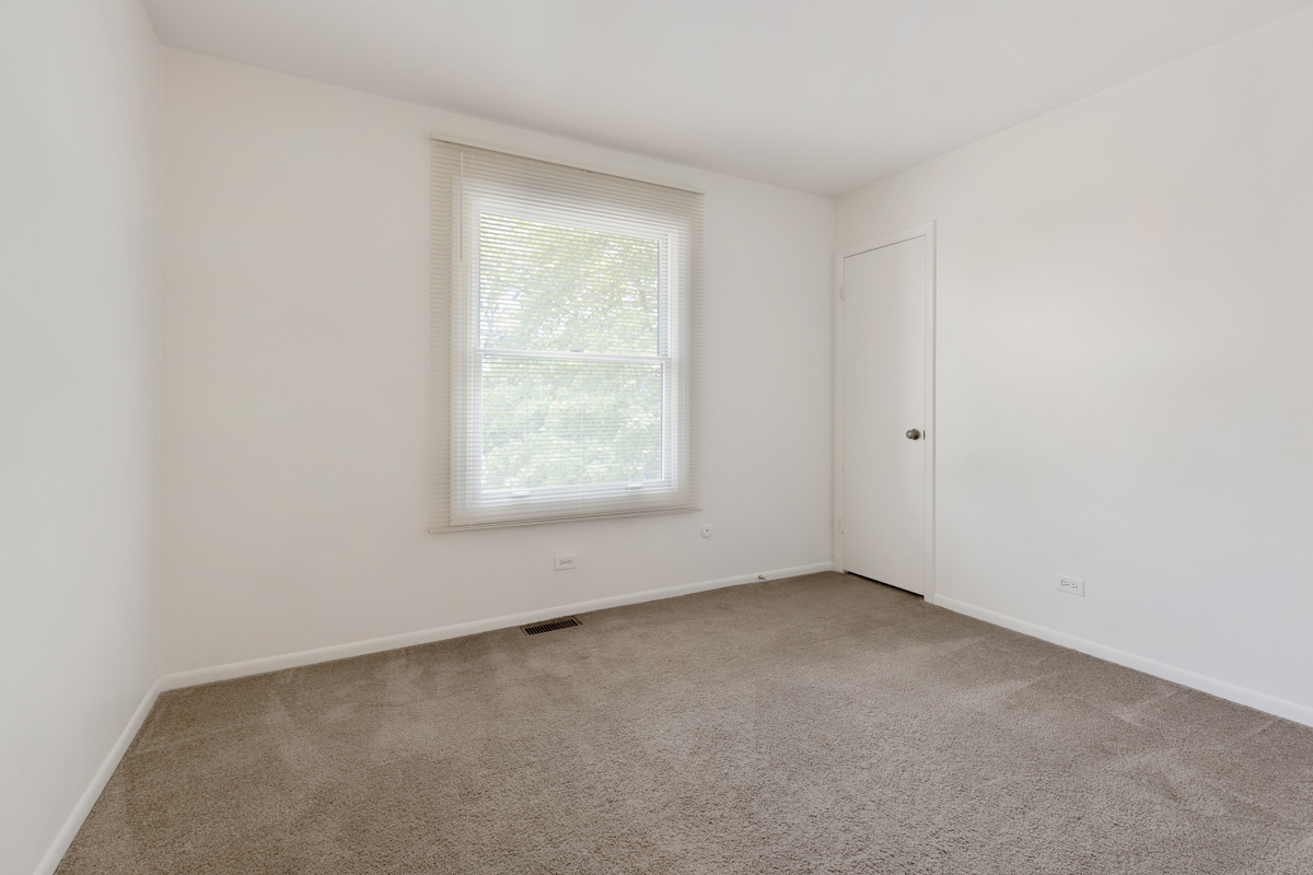 772 Leicester Road, Unit 772 Elk Grove Village, IL 60007 - Photo 14 of 21 an empty room with a window