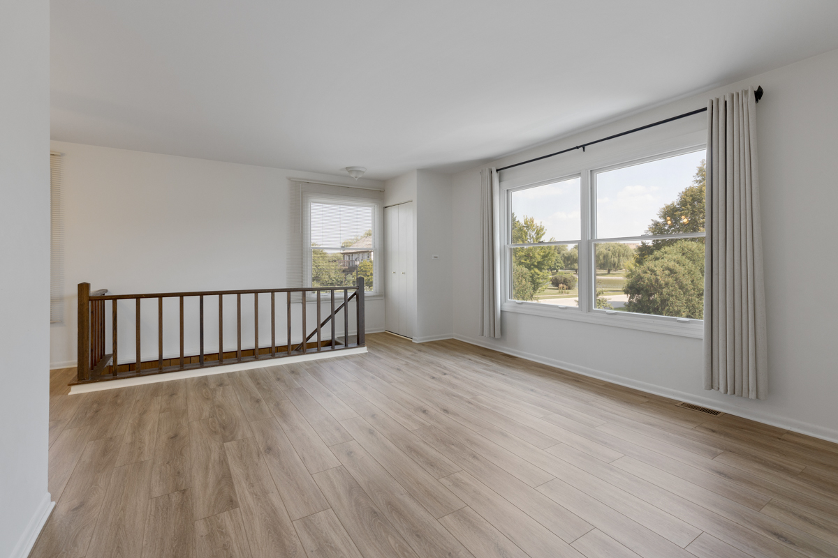 772 Leicester Road, Unit 772 Elk Grove Village, IL 60007 - Photo 2 of 21 a view of a room with wooden floor and a window