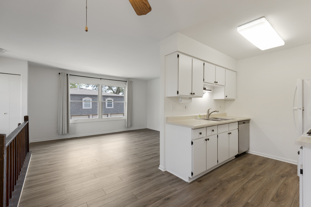 772 Leicester Road, Unit 772 Elk Grove Village, IL 60007 - Photo 6 of 21 a kitchen with granite countertop white cabinets and wooden floor