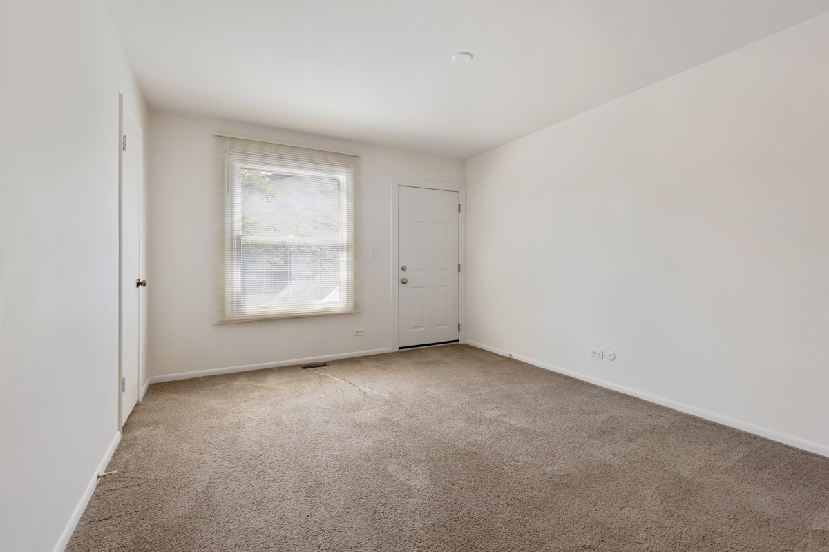 772 Leicester Road, Unit 772 Elk Grove Village, IL 60007 - Photo 10 of 21 an empty room with windows