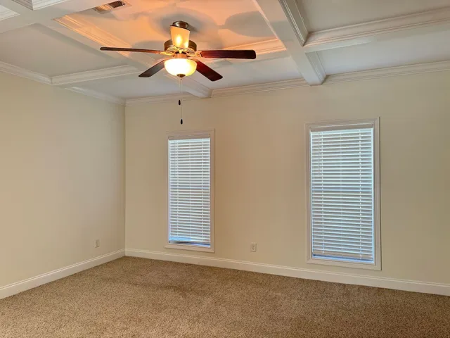an empty room with closet and a chandelier fan