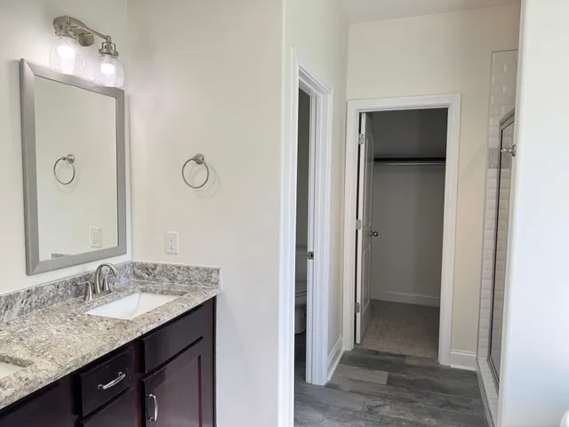 a white toilet sitting next to a white wall