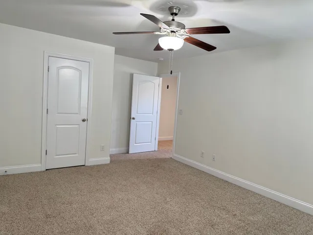 an empty room with a chandelier fan and a chandelier fan