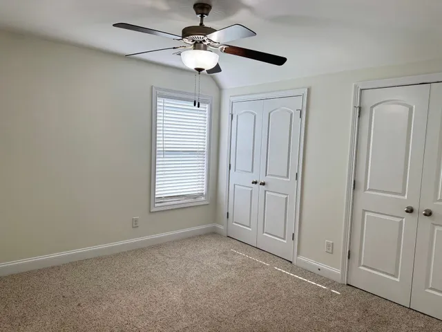 a bathroom with a granite countertop sink toilet and mirror