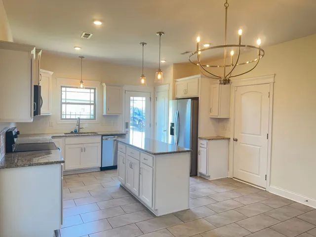 a large kitchen with kitchen island a sink stainless steel appliances and cabinets