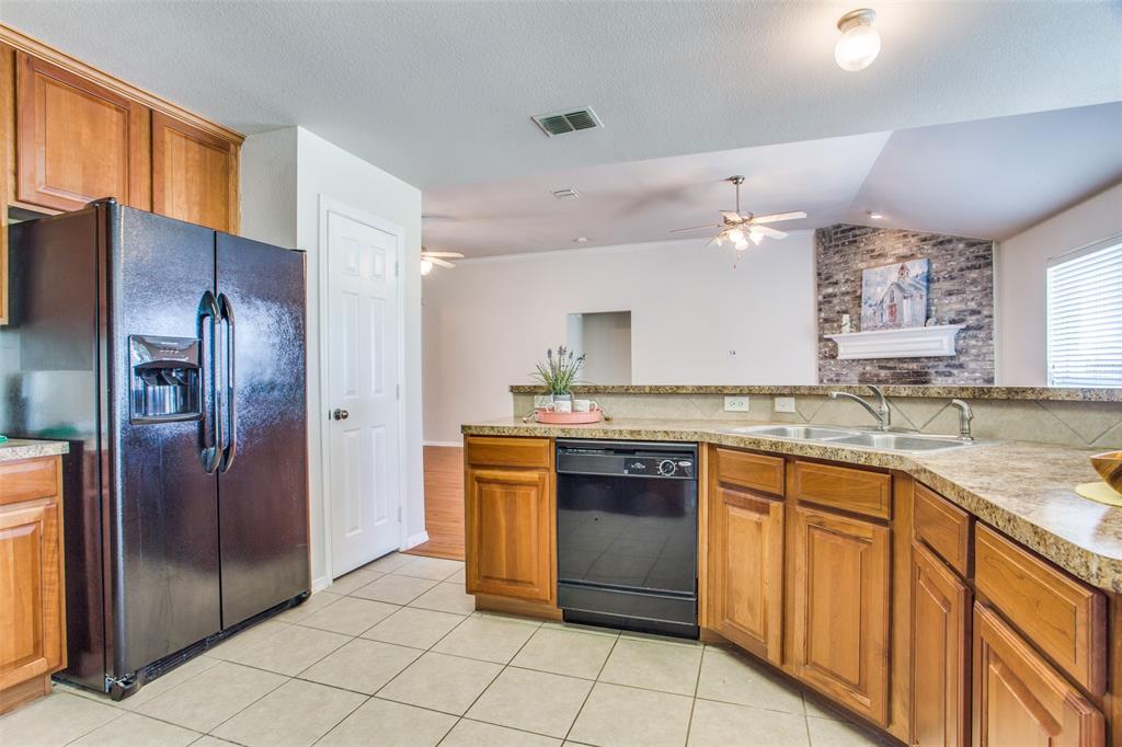 149 Shumard Drive Aledo, TX 76008 - Photo 4 of 12 a kitchen with stainless steel appliances granite countertop a refrigerator and a sink